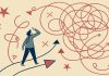 Rethinking Risk in Industrial and Manufacturing Environments Confused businessman standing at crossroads looking for solution to complex problem choosing right direction finding way out of tangled road